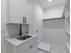 This laundry room features white marble floors, sink with white cabinets, and open closet at 2861 Tree Top Rd, Dacula, GA 30019