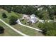 Aerial view featuring the home, outbuildings, circular driveway, and landscaped yard on a beautiful tree filled lot at 3898 Ridge Rd, Buford, GA 30519