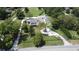 Aerial view featuring the home, outbuildings, circular driveway, and landscaped yard on a beautiful tree filled lot at 3898 Ridge Rd, Buford, GA 30519