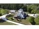 Aerial view of a stunning property featuring a large home, extended deck, and outbuildings surrounded by green landscape at 3898 Ridge Rd, Buford, GA 30519