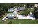 An aerial view of a white home with dark trim, showcasing a sprawling property featuring multiple structures and verdant landscaping at 3898 Ridge Rd, Buford, GA 30519