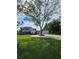 Exterior shot featuring a large tree in the front yard of a white home with dark trim, with an outbuilding in the rear at 3898 Ridge Rd, Buford, GA 30519