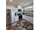 Well-lit kitchen with stainless steel appliances, white cabinets, and a floral rug adding charm at 3898 Ridge Rd, Buford, GA 30519