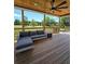 Exterior shot of a covered porch with wooden floors, outdoor furniture, and peaceful greenery view at 3898 Ridge Rd, Buford, GA 30519