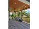 Covered outdoor porch area with stylish decor, wood ceiling, wood floors, and serene view at 3898 Ridge Rd, Buford, GA 30519
