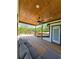 Covered outdoor porch area with stylish decor, wood ceiling, wood floors, and serene view at 3898 Ridge Rd, Buford, GA 30519
