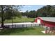 Overhead view of a large property featuring a red barn, paddock, and sprawling grassy fields at 3898 Ridge Rd, Buford, GA 30519