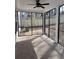 The screened in porch has black trim windows and doors, ceiling fans, and concrete flooring at 1641 Lacebark Elm Way, Lawrenceville, GA 30045