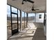 The screened in porch has black trim windows and doors, ceiling fans, and concrete flooring at 1641 Lacebark Elm Way, Lawrenceville, GA 30045