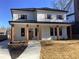 Two-story farmhouse with white siding, dark metal roof, and a welcoming front porch at 408 Autry St, Norcross, GA 30071