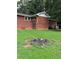 Brick home with grassy backyard and fire pit at 5595 Stagecoach Rd, Rex, GA 30273
