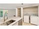Kitchen island with stainless steel sink next to stainless dishwasher and laundry center at 4315 Orchard Park Ct, Stone Mountain, GA 30083