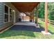 Covered patio with concrete flooring, wooden support beams, and a fire pit at 138 Stargaze Rdg, Canton, GA 30114