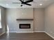 Bright living room features modern fireplace with a decorative mantel and a ceiling fan at 5015 Renvyle Dr. (Lot 12) Dr, Atlanta, GA 30339