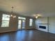 Open living room with a fireplace, ceiling fan, and a door to the outdoor patio at 5015 Renvyle Dr. (Lot 12) Dr, Atlanta, GA 30339