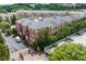 Aerial view of the brick apartment buildings with pool, parking, and manicured trees at 1735 Peachtree Ne St # 321, Atlanta, GA 30309