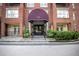 Beautiful building entrance with covered awning, brick facade, and well-maintained landscaping at 1735 Peachtree Ne St # 321, Atlanta, GA 30309