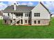 The back of this home offers brick accents and a staircase to a porch overlooking a large grassy area at 216 Ewing Way, Dacula, GA 30019