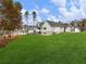 Expansive green backyard featuring a well-manicured lawn, complemented by the home's rear facade with neutral siding and brick foundation at 216 Ewing Way, Dacula, GA 30019