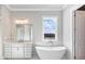 Luxurious bathroom featuring a soaking tub, double vanity, and natural light at 216 Ewing Way, Dacula, GA 30019