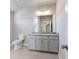 Bathroom with gray vanity, granite countertop, tiled floor, toilet, and large mirror at 216 Ewing Way, Dacula, GA 30019