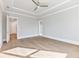 Bright bedroom with hardwood floors, tray ceiling, ceiling fan, and access to other rooms at 216 Ewing Way, Dacula, GA 30019