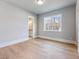 Bright bedroom features hardwood floors, white trim, and large window with a view of the woods at 216 Ewing Way, Dacula, GA 30019