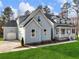 Charming two-story home features a light blue exterior, inviting front porch, and a two-car garage, surrounded by lush greenery at 216 Ewing Way, Dacula, GA 30019