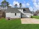 Rear exterior of the home with gray siding, showcasing a well-maintained lawn and attached two-car garage with a paved driveway at 216 Ewing Way, Dacula, GA 30019