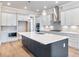 Bright, spacious kitchen features a large island, stainless steel appliances, and modern pendant lighting at 216 Ewing Way, Dacula, GA 30019
