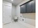 Well-lit laundry room with utility sink, gray cabinets, and washer/dryer hookups at 216 Ewing Way, Dacula, GA 30019