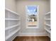 Walk-in pantry with window and built-in shelving for organized storage at 216 Ewing Way, Dacula, GA 30019