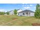 Spacious backyard showing lush green grass with newly planted trees and a view of the home at 8593 Preakness Pass, Lithonia, GA 30058