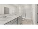 Bathroom featuring double sinks with granite countertops, a large mirror, and a glass enclosed shower at 8593 Preakness Pass, Lithonia, GA 30058