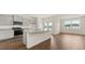 Open-concept kitchen with gray cabinets, stainless steel appliances, a center island, and hardwood floors at 8593 Preakness Pass, Lithonia, GA 30058