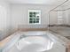 Luxurious bathroom with a large jacuzzi tub, marble countertop, and a modern glass shower at 2122 Belhaven Se Ln, Atlanta, GA 30315