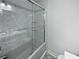 Bathroom close-up featuring a shower with frameless glass doors and marbled-tile walls at 2122 Belhaven Se Ln, Atlanta, GA 30315