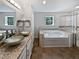 Elegant bathroom featuring dual vessel sinks, a soaking tub, and a glass-enclosed shower for a spa-like experience at 2122 Belhaven Se Ln, Atlanta, GA 30315