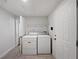 Bright laundry room with updated washer and dryer, tiled floor, and shelving for organization at 2122 Belhaven Se Ln, Atlanta, GA 30315