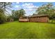 Expansive backyard with a brick house, green lawn, trees, and privacy fencing at 5795 Stewart Mill Rd, Douglasville, GA 30135