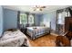 Cozy bedroom featuring a ceiling fan, two beds, hardwood floors and blue walls at 5795 Stewart Mill Rd, Douglasville, GA 30135