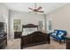 Bright main bedroom with a decorative bed, ceiling fan, and natural light from the windows at 5365 Crow Rd, Cumming, GA 30041