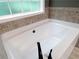 Neutral soaking tub with a large picture window at 1269 Heritage Dr, Villa Rica, GA 30180