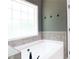 Large soaking tub with tiled backsplash in a soothing, neutral-toned bathroom at 1269 Heritage Dr, Villa Rica, GA 30180
