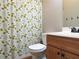 Functional bathroom with a floral shower curtain, toilet, and vanity with storage at 1269 Heritage Dr, Villa Rica, GA 30180