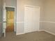 Inviting bedroom with carpet, a closet, paneled walls, and access to another room at 1269 Heritage Dr, Villa Rica, GA 30180