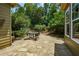 Outdoor patio with stone and seating area surrounded by lush landscaping and trees at 705 Springer Mountain Dr, Canton, GA 30114