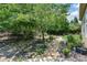 A serene backyard with a stone path, mature trees, and a black iron fence at 705 Springer Mountain Dr, Canton, GA 30114