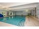 Indoor swimming pool with steps and lane markers, surrounded by neutral decor and large windows at 705 Springer Mountain Dr, Canton, GA 30114