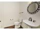 Cozy powder room featuring a pedestal sink, decorative mirror, and wood floors at 705 Springer Mountain Dr, Canton, GA 30114